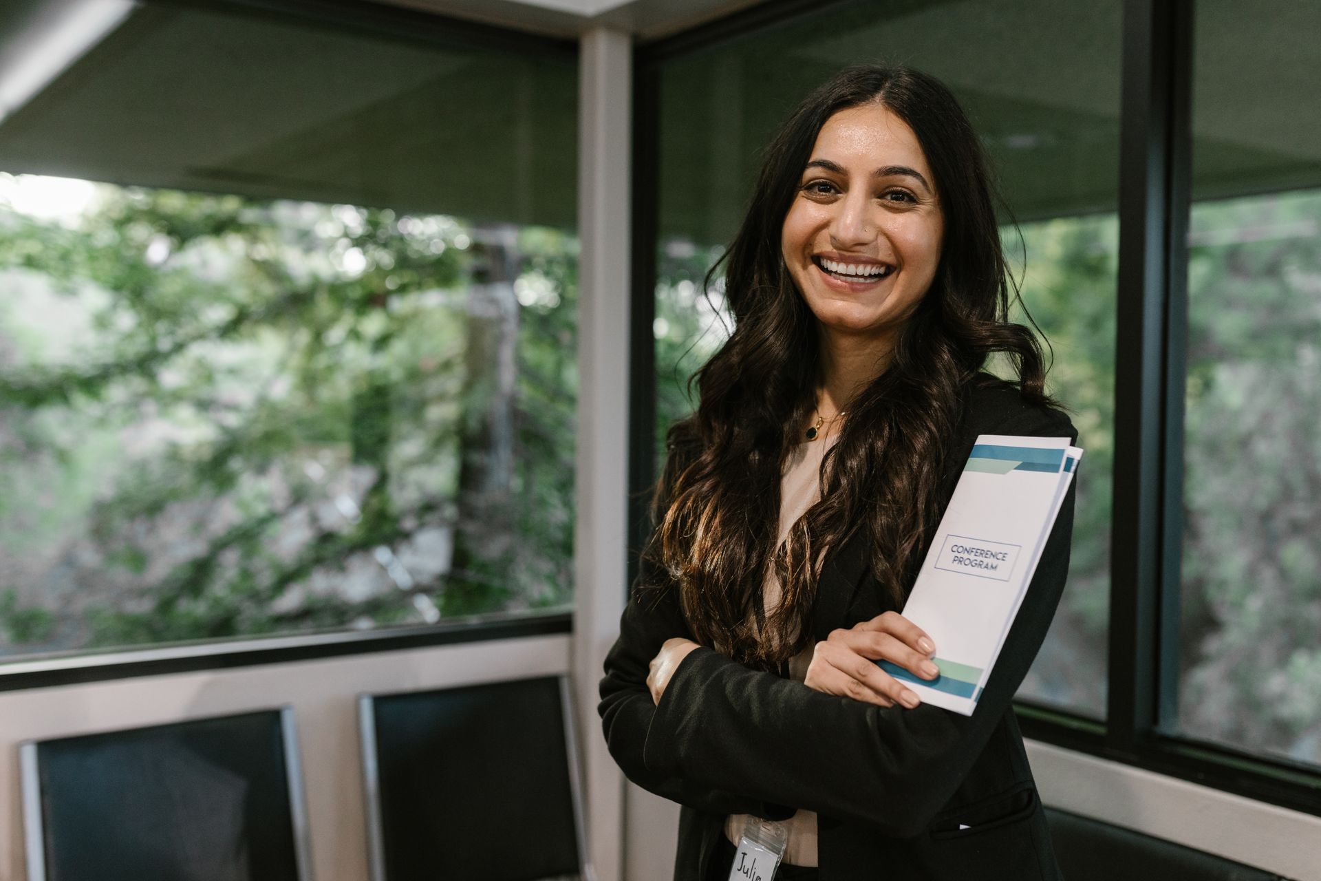 A smiling attendee holding a conference program