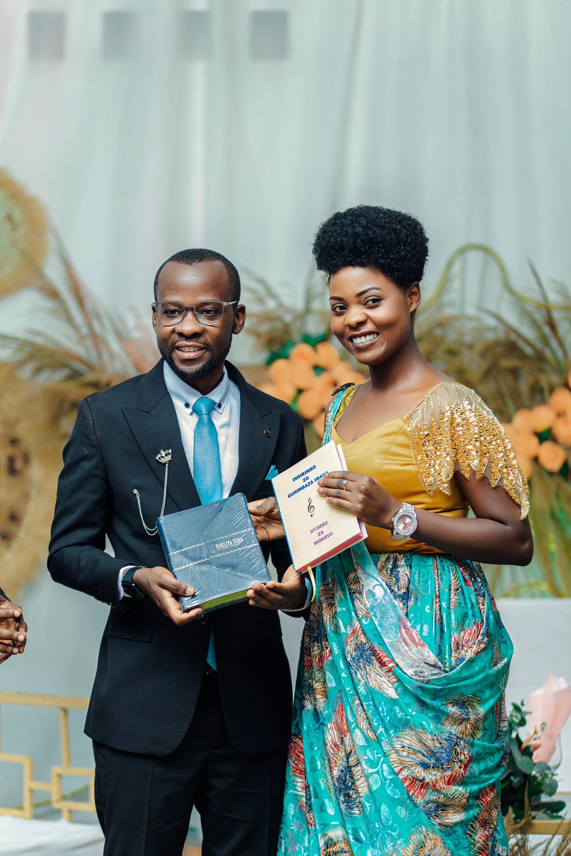 Two award winners smiling and holding their awards at a gala