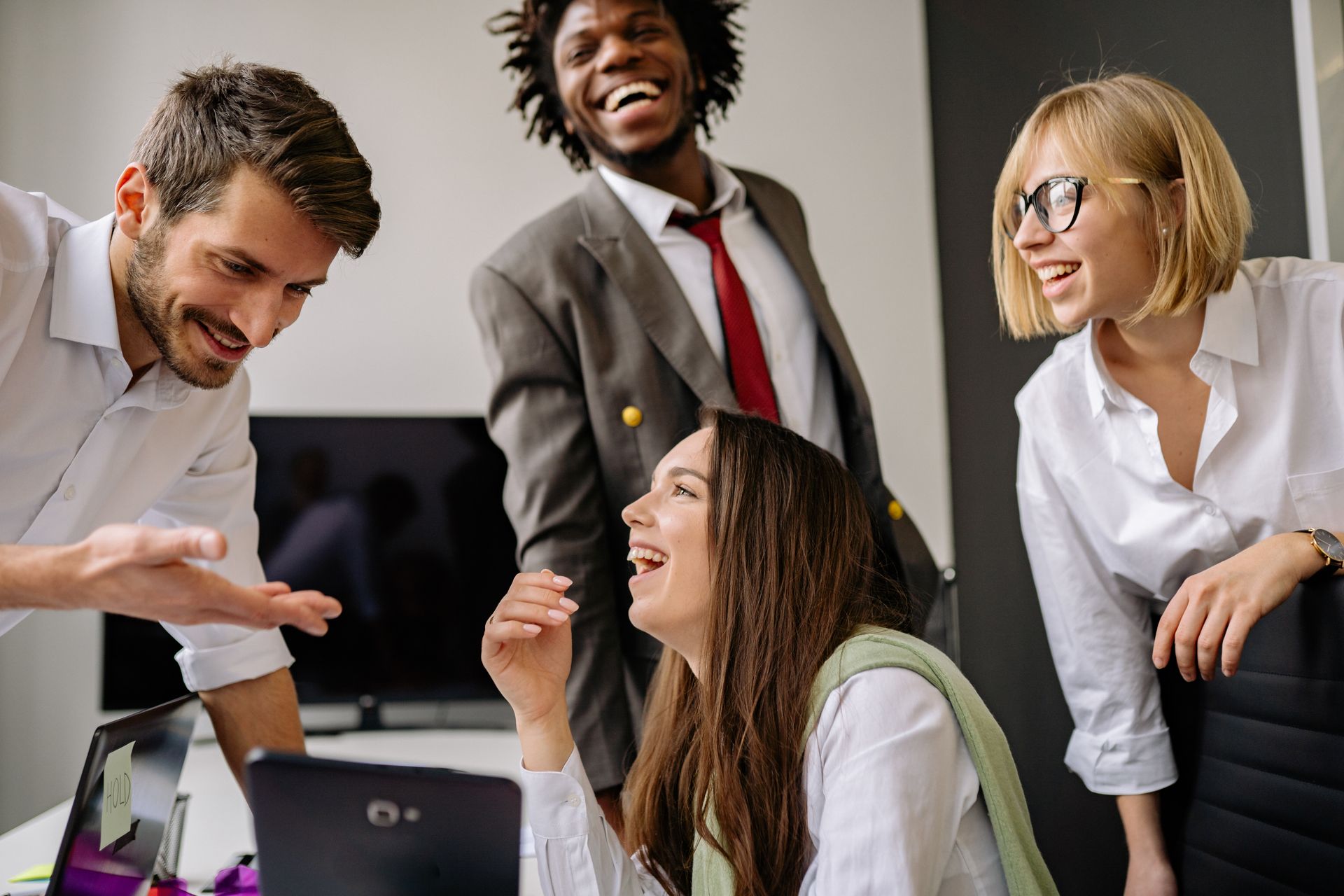 Colleagues laughing together in a bright office
